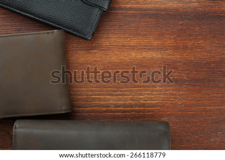 three male purse on wood background