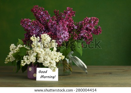 Good morning note and lilac flower on the wooden table