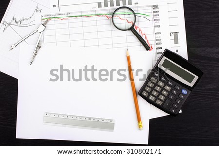 graph pencil line calculator and pen on a black wooden background