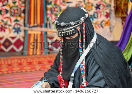 Bedouin Woman wears traditional Arabic Clothes doing kraft hand made Sado in Hijin festival activity in Taif City in Saudi Arabia. Mawsim Al Taif