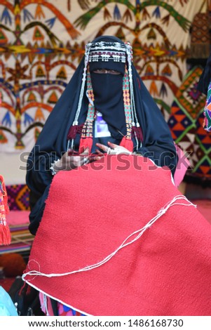 Bedouin Woman wears traditional Arabic Clothes doing kraft hand made Sado in Hijin festival activity in Taif City in Saudi Arabia. Mawsim Al Taif