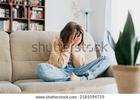 Tired schoolgirl girl sits on the couch and holds on with her hands. Per head. Children's stress from exams and fatigue from studying. The need for relaxation Stok fotoğraf © 