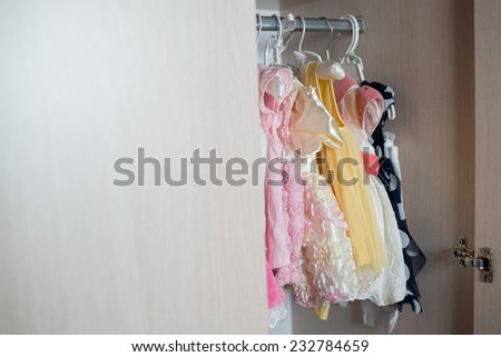 baby clothes hanging on the rack in the closet