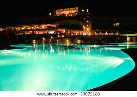 Night time photo of a swimming pool at a tropical resort