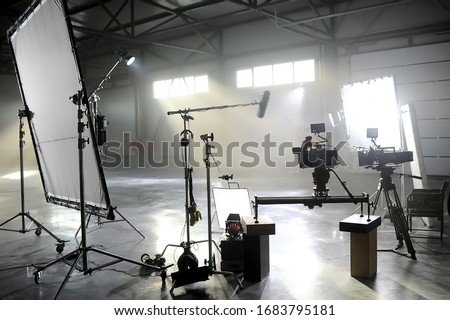 Profesional video studio.Behind-the-scenes of a video shooting.Behind the shooting production silhouette of camera and equipment in studio.Selective focus.