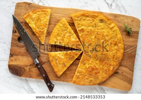 Chickpea pancake Farinata with rosemary herb. Homemade traditional Italian cuisine dish cut in pieces. Stockfoto © 