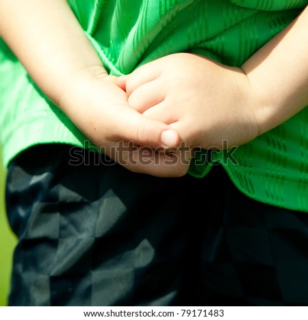 young soccer player with hands crossed behind back