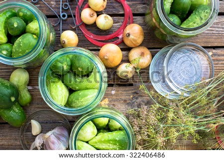 Pickling cucumbers. Garden table full of ingredients, cucumbers, onions, garlic, horseradish, dill.