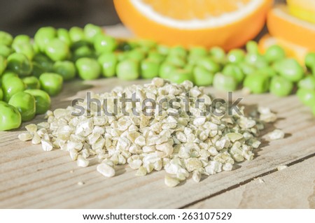 A pile of dried peas, in front of fresh peas