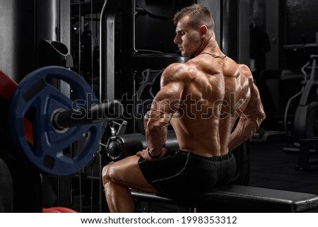 Muscular man showing back muscles in gym. Strong male rear view Stock foto © 