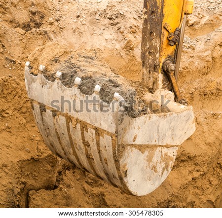 On the construction site -Excavator digging a deep trench