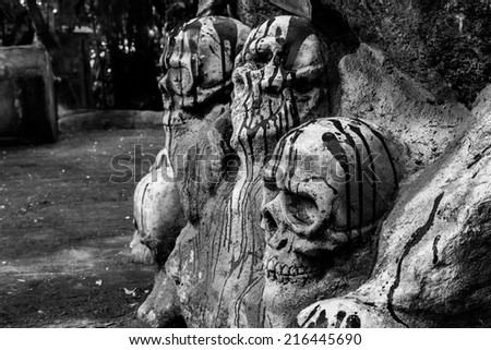 Human skulls in stone with blood sculpture black and white.