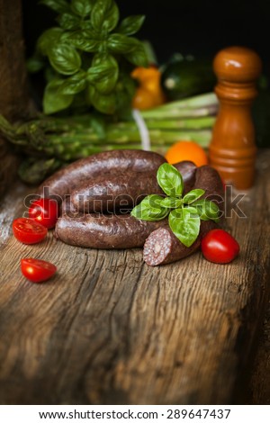 Black pudding, with cut slices, on chopping board over stone background. Krupniok really Polish black pudding.