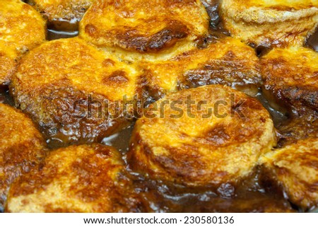Baked cheese dumplings on a beef stew close up with a medium depth of field