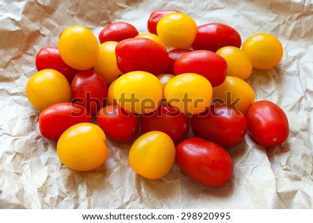 Red and yellow cherry tomatoes in a brown crumpled up paper bag