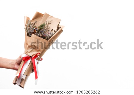 Similar – Image, Stock Photo Hand holding bouquet of pink and white flowerson wooden table at flower shop. Floristics and selling flowers small business. Pink fresh spring floral background with copy space on light gray background.