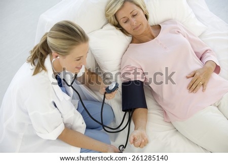 Doctor Checking senior patient blood pressure