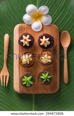 Cap cakes on a wooden tray and wooden spoon and fork