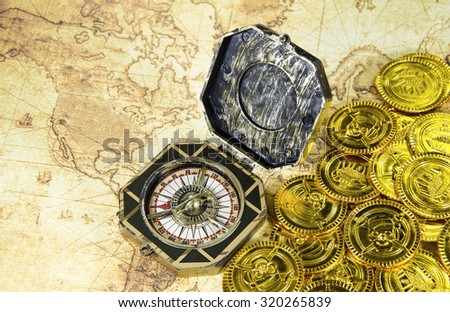 compass and pirate golden coin on a old world map