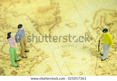 mini model of a man  woman and oldman on a old world map