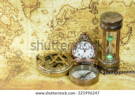old compass and hourglass on a old world map