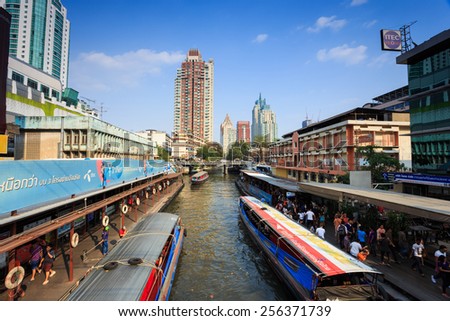 Bangkok, Thailand - February 8, 2015: Skyscraper and Pratunam pier in Bangkok; water transportation by speed boat is one of the alternative choice for solving the traffic congestion problem in Bangkok