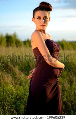 Beautiful girl from Poland, outdoor portrait. Young female model posing with different hands gesture. Blue sky with single clouds and green fields as background.