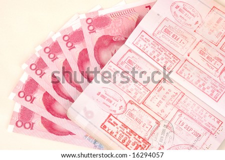 Passport full of stamps from China and Hongkong borders together with Chinese money, RMB banknotes.