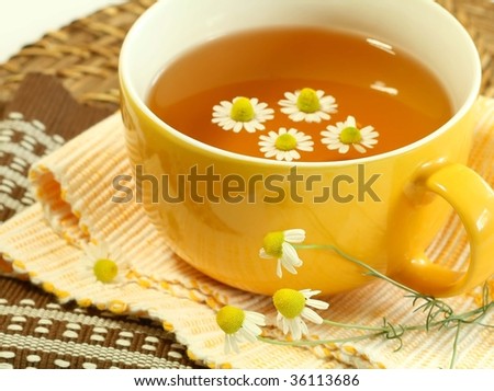 Teacup and  teapot with soothing herbal camomile tea.