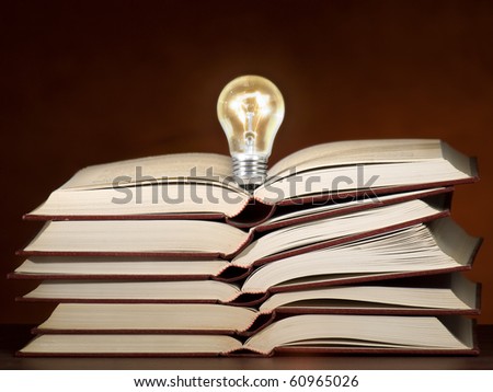 Lit light bulb on the stack of books, can be used as concept for education,ideas,solution