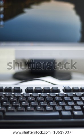Shallow depth of field on a computer keyboard. On the background can be seen a part of the desktop LCD monitor. The focus is on the keyboard buttons.