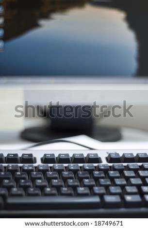 Shallow depth of field on a computer keyboard. On the background can be seen a part of the desktop LCD monitor. The focus is on the keyboard buttons.
