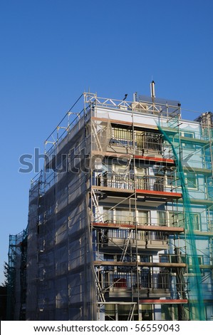 Building with scaffolding and green safety net