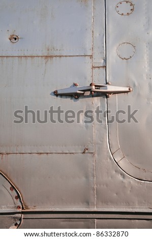 Rivets Part of an airplane fuselage with rivets and door hinge