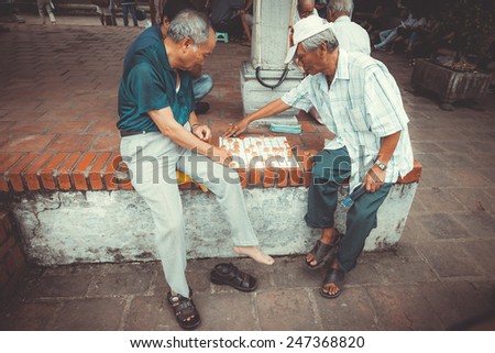VIETNAM, HANOI - 23 SEPTEMBER 2013: local residents relax and play checkers on the island of the Lake of the Restored Sword