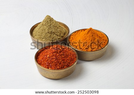 turmeric, coriander and red chilli powder in metal bowls