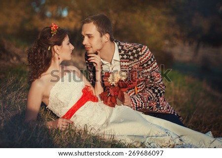 Portrait of the bride and groom lying in the grass
