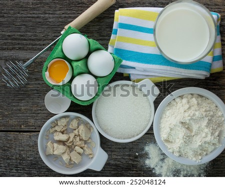 ingredients for making pancakes - milk, eggs, yeast, flour, sugar. Shallow depth of field