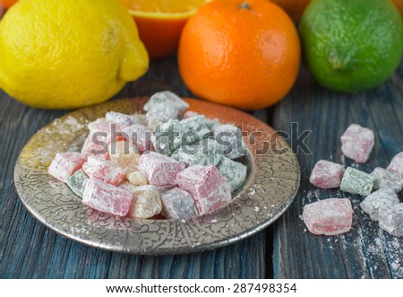 Citrus jelly candies in the bowl on the table and citrus - lime, lemon, orange