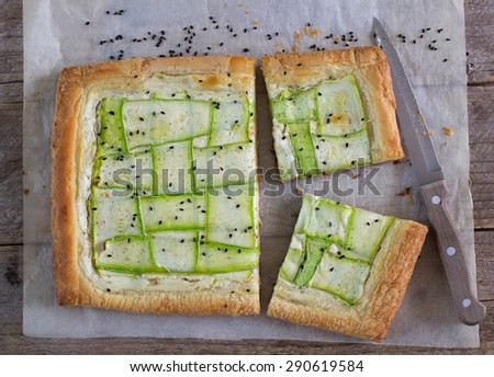Homemade tart  of puff pastry with strips of fresh zucchini and goat cheese. Selective Focus