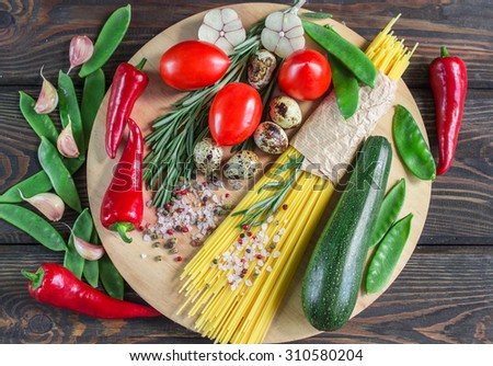 Ingredients for cooking pasta with vegetables - spaghetti, zucchini, tomatoes, garlic, rosemary, pepper. Selective focus