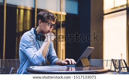 Businessman in formal wear watching online webinar during distance work with startup project on portable pc connected to 4g wireless, male trader in spectacles checking information on website