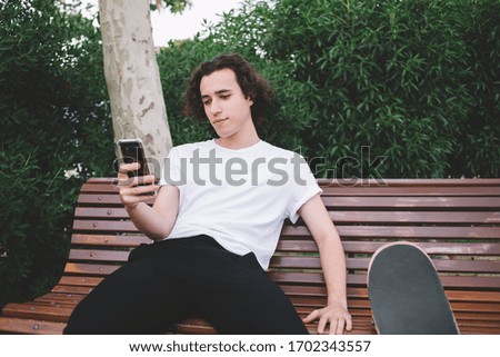 Similar – Image, Stock Photo Carefree male skater browsing cellphone in city