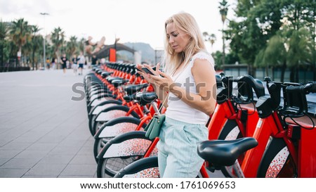 Similar – Image, Stock Photo Woman renting bike using rental app on mobile phone. Using bike sharing city service. Paid rent of electric scooter. Using smartphone to rent and pay for public eco transport