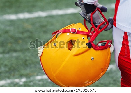 american football helmet in hand