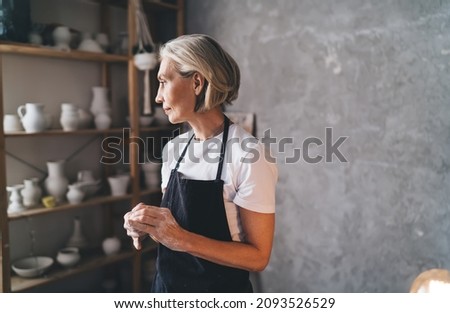 Similar – Image, Stock Photo Senior artist standing in home workshop and choosing paints