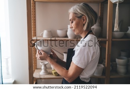 Similar – Image, Stock Photo Senior artist standing in home workshop and choosing paints