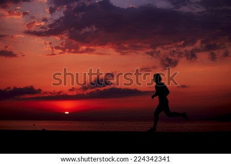 Male runner with athletic figure running alone at orange sunrise on the beach, fitness training on the beach, beautiful runner silhouette in action, fitness and healthy lifestyle