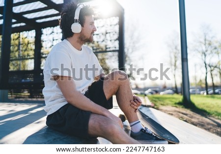 Similar – Foto Bild Entspannter männlicher Skater beim Musikhören in der Stadt