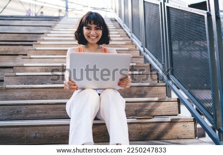 Similar – Image, Stock Photo Glad woman sitting near building wall in city